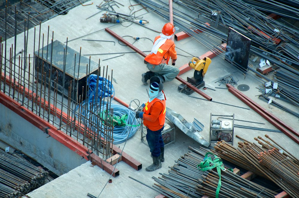 Laborers teamwork on construction beams